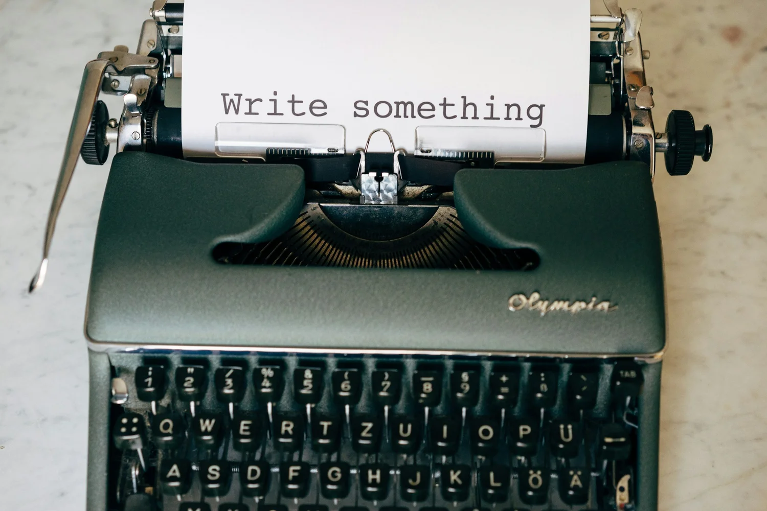 Typewriter with a page that reads write something